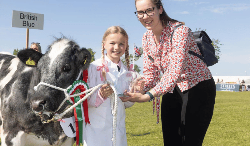 Photo of a mother and daughter holding a cow at the Nottinghamshire County Show